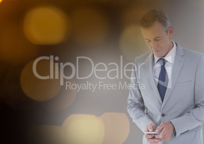Businessman texting in colored lights background