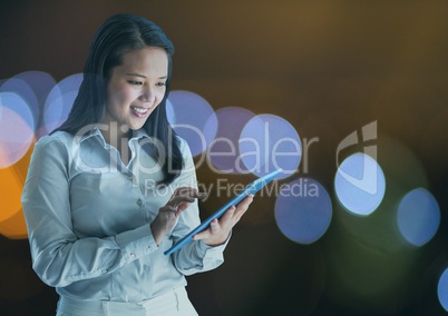 Smiling woman using a digital tablet with spotlights