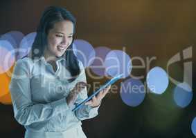 Smiling woman using a digital tablet with spotlights