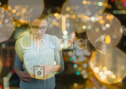 photographer taking a photo with vintage camera. Blurred city lights background and yellow blurred l