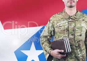 Soldier holding books in front of the american flag