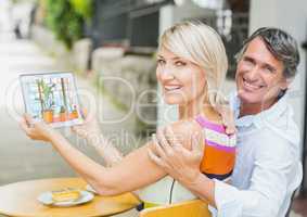 Happy couple showing the 3D design of the office with  tablet. ( color: blue, green and orange)