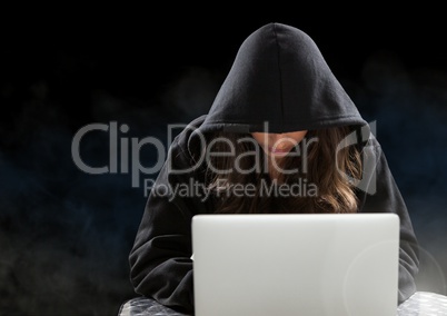 Woman hacker working on laptop in front of black background