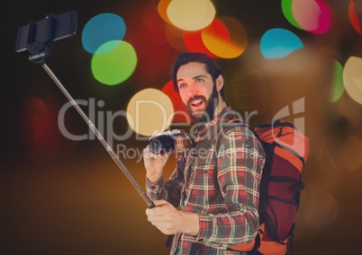 Tourist taking selfie  with his camera  and his phone against glowing background