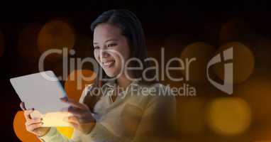 Smiling woman using a digital tablet in lights
