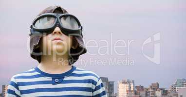 Boy with goggles against buildings and evening sky