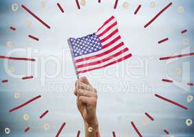 Hand holding american flag against blurry blue wood panel with firework doodles