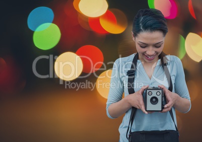 Photographer looking at her camera against glowing background