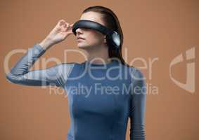 Woman in virtual reality headset against brown background