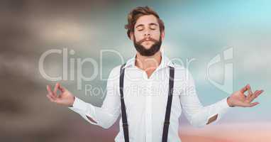 Millennial man meditating against blurry blue brown background