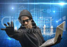 Hacker extending his hand while working on laptop in front of digital blue background