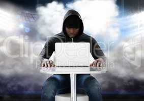 Hacker using a laptop in front of cloudy background