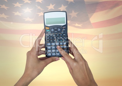 Hands using a calculator against american flag