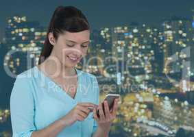 Smiling woman texting against a city on background