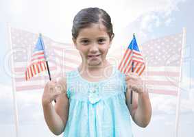 Girl holding american flags against fluttering american flags
