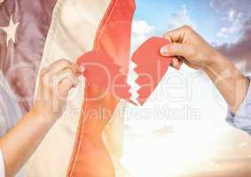 Hands holding a broken heart against 3d fluttering american flag