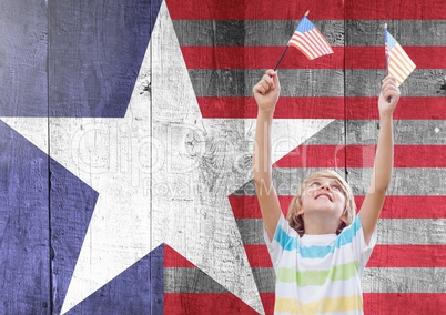 Smiling boy holding american flags against wooden american flag background