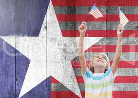 Smiling boy holding american flags against wooden american flag background