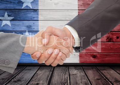 3d handshaking against a wooden background with american flag