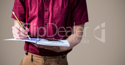 College student mid section with book against brown background