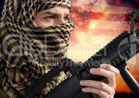 Soldier holding a weapon in front of american flag