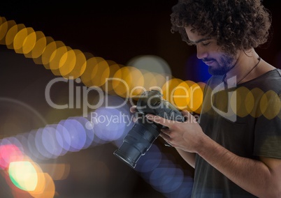 Photographer looking at his camera against glowing background