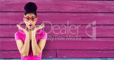 Surprised woman standing on a pink wooden background