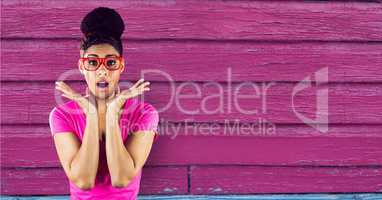 Surprised woman standing on a pink wooden background