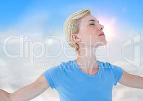 Close up of woman with arms outstretched against sunny sky