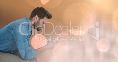 Smiling man texting in colored lights background