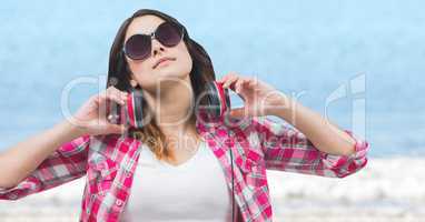 Woman with headphones soaking up sun against blurry water