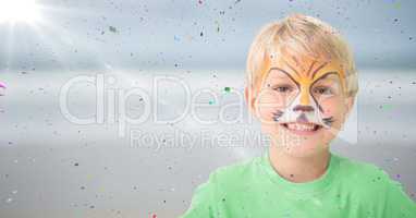 Boy with tiger face paint against blurry beach with flare and confetti