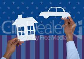 Hand holding a paper house and paper car against american flag