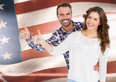 Couple thumbs up  against american flag
