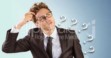 Frustrated business man against blue background and 3D question marks