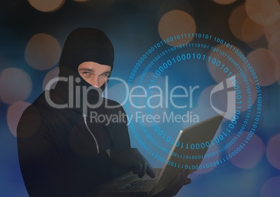 Hacker with hood using a laptop in front of digital background