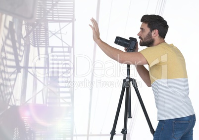 Photographer with his camera against light background