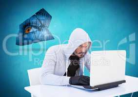 Hacker with glove using a laptop in front of blue background