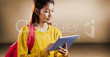 College student with tablet against brown wall