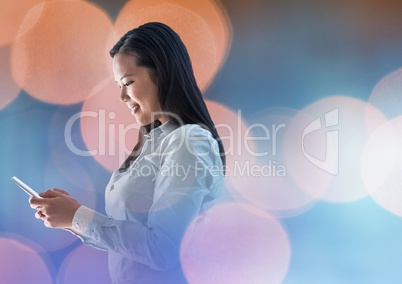Smiling woman texting in colored lights