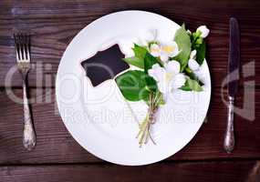 White round plate with iron knife and fork