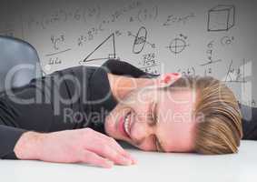 Frustrated business man on desk against grey background and math graphics
