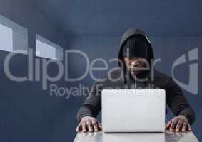 Hacker working on laptop in dark room