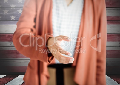 Woman shaking hand against american wooden flag