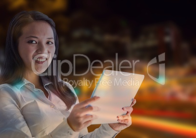 Smiling woman using a digital tablet in lights