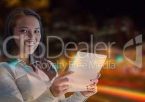 Smiling woman using a digital tablet in lights