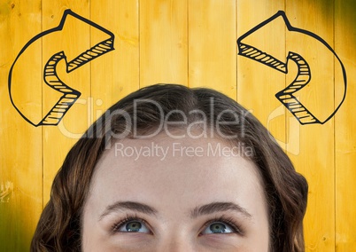 Top of woman's head looking up at 3D grey curved arrows against yellow wood panel