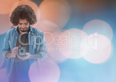 Photographer looking at his camera against glowing background