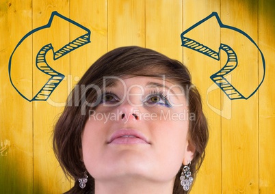 Woman looking up at blue curved 3D arrows against yellow wood panel