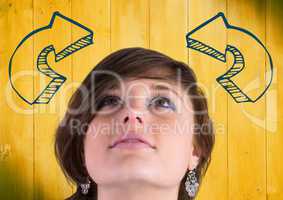 Woman looking up at blue curved 3D arrows against yellow wood panel